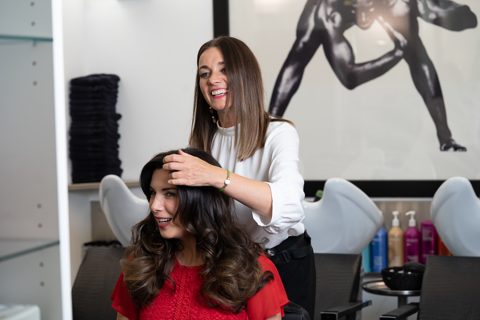 Eine Frau wird in einem Hairdreams-Salon von einer Friseurin beraten.