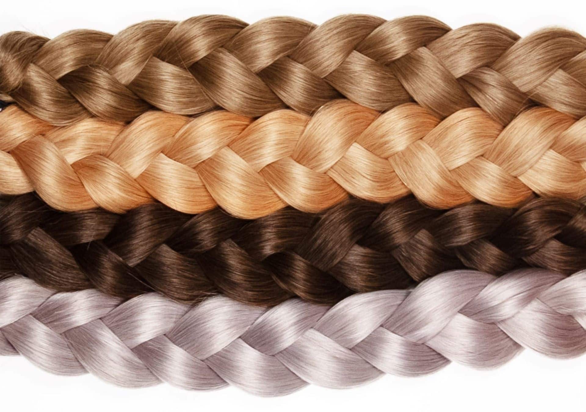 Four braided hair plaits in four trendy colours lie next to each other.